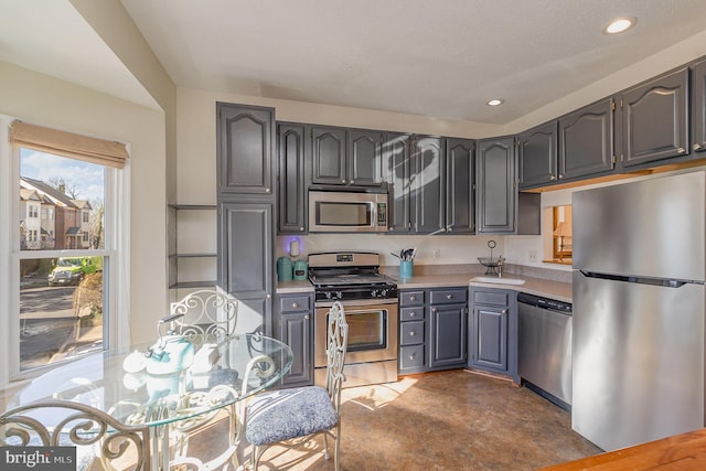 kitchen with stainless steel appliances, light countertops, and recessed lighting