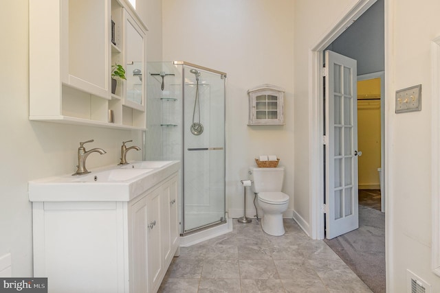 bathroom with visible vents, toilet, a stall shower, vanity, and baseboards