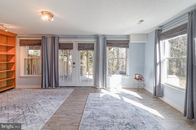 entryway featuring baseboards, visible vents, a textured ceiling, french doors, and light wood-style floors