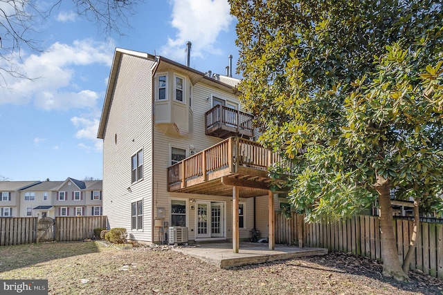 rear view of house featuring a wooden deck, a fenced backyard, french doors, a patio area, and central AC