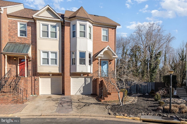 townhome / multi-family property with driveway, brick siding, and an attached garage