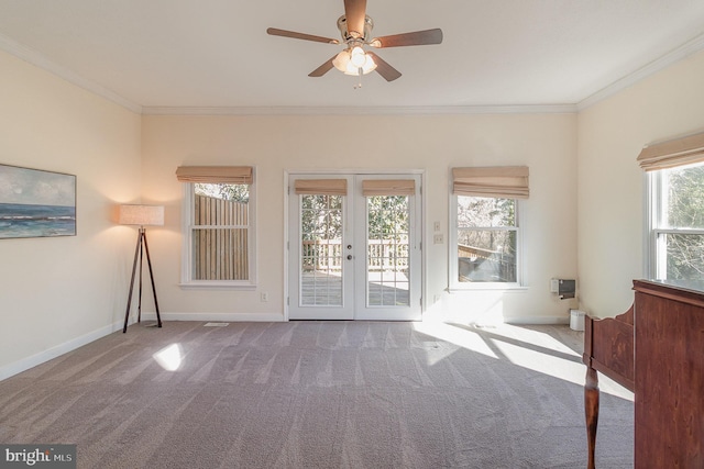 interior space featuring french doors, ornamental molding, carpet flooring, ceiling fan, and baseboards