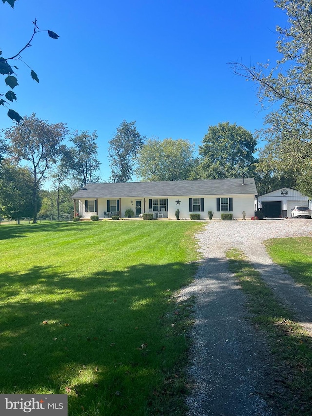 view of front of property featuring a garage, an outdoor structure, and a front yard