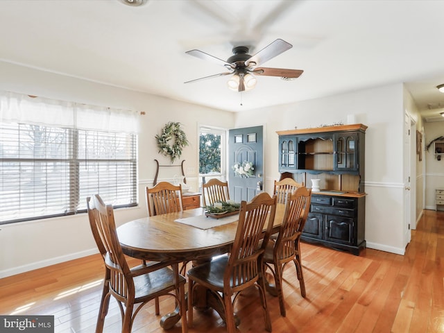 dining space with ceiling fan and wood-type flooring