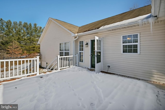 view of snow covered rear of property