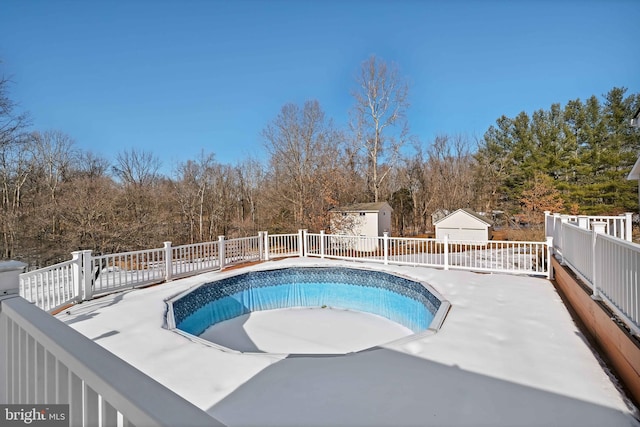 view of swimming pool featuring an outbuilding, a patio, a storage shed, and a fenced in pool