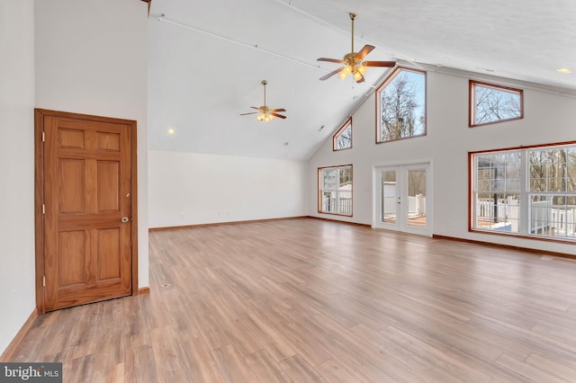 unfurnished living room featuring high vaulted ceiling, a ceiling fan, baseboards, french doors, and light wood finished floors