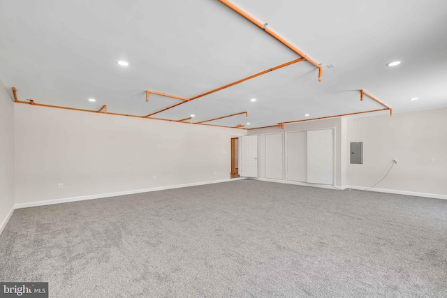 unfurnished living room with recessed lighting, baseboards, electric panel, and carpet flooring