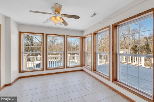 unfurnished sunroom featuring visible vents and a ceiling fan