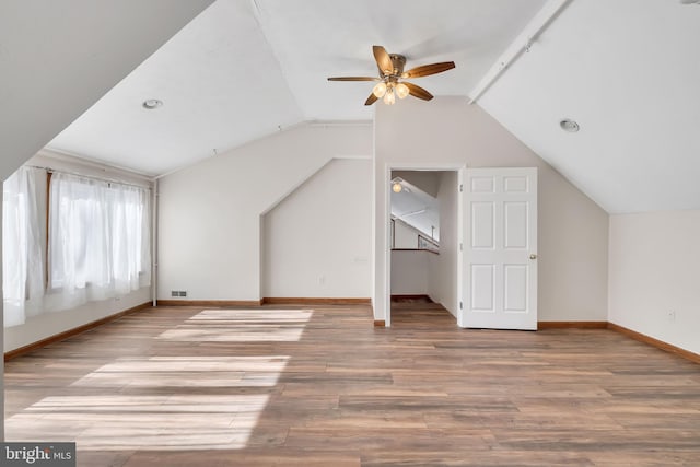 bonus room with lofted ceiling, visible vents, baseboards, and wood finished floors