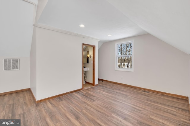 bonus room with vaulted ceiling, wood finished floors, visible vents, and baseboards