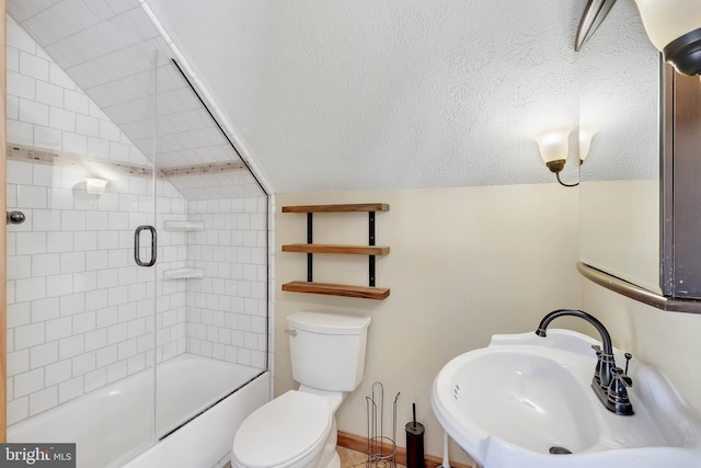 bathroom with a textured ceiling, lofted ceiling, toilet, a sink, and combined bath / shower with glass door