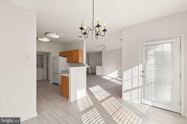 kitchen featuring pendant lighting, ceiling fan with notable chandelier, white fridge, and light wood-type flooring