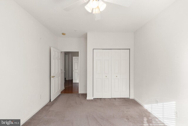 unfurnished bedroom with light carpet, a closet, and ceiling fan