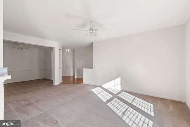 empty room with ceiling fan and light carpet