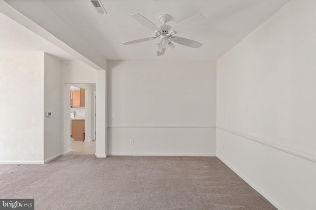 empty room featuring ceiling fan and light carpet