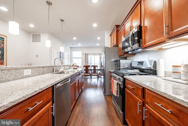 kitchen featuring pendant lighting, sink, light stone counters, and stainless steel appliances