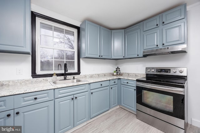 kitchen featuring blue cabinetry, sink, electric range, and light hardwood / wood-style floors