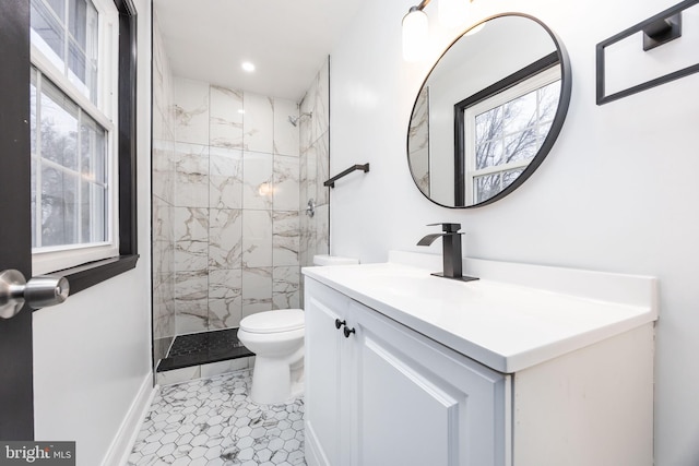 bathroom with vanity, toilet, and a tile shower