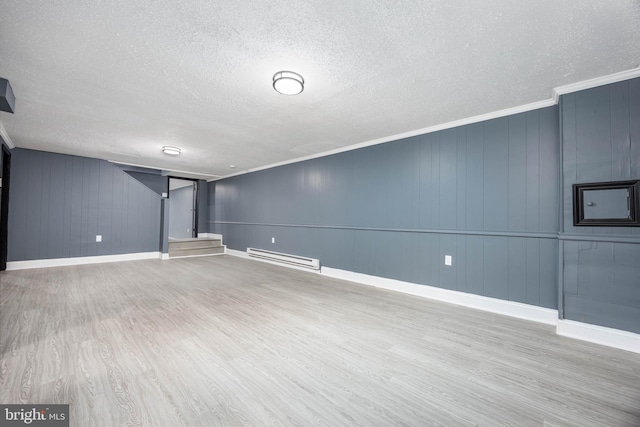 basement featuring crown molding, hardwood / wood-style flooring, a textured ceiling, and baseboard heating