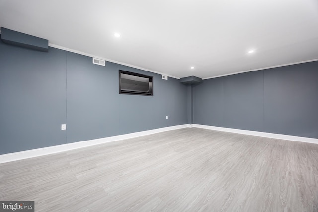 basement featuring crown molding and light hardwood / wood-style floors