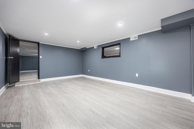 basement with crown molding and light hardwood / wood-style flooring