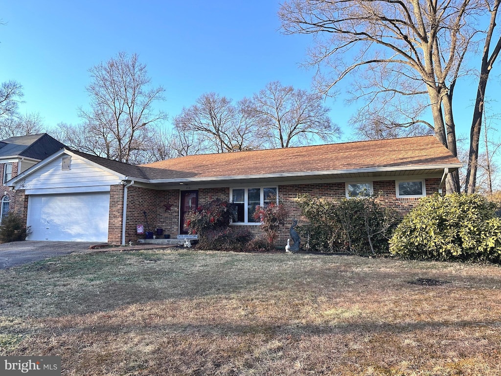 single story home with a garage and a front lawn