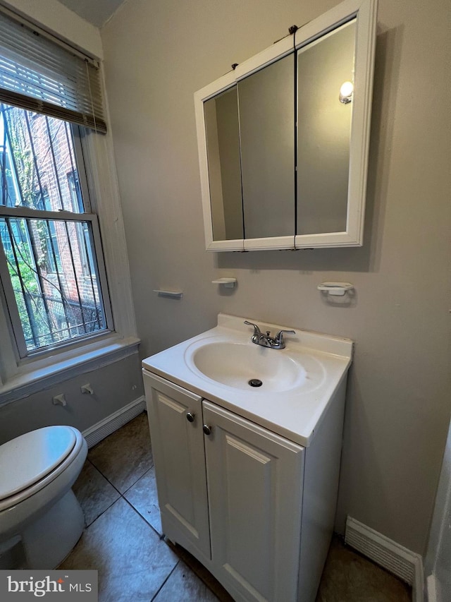 bathroom featuring tile patterned flooring, vanity, and toilet