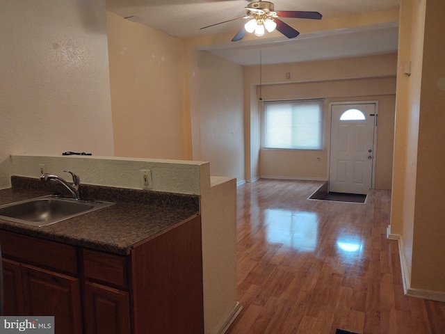 kitchen with ceiling fan, light hardwood / wood-style floors, sink, and dark brown cabinets