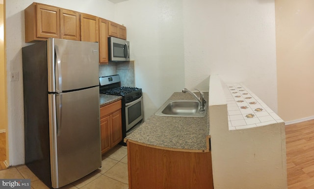 kitchen featuring appliances with stainless steel finishes, sink, and light tile patterned floors