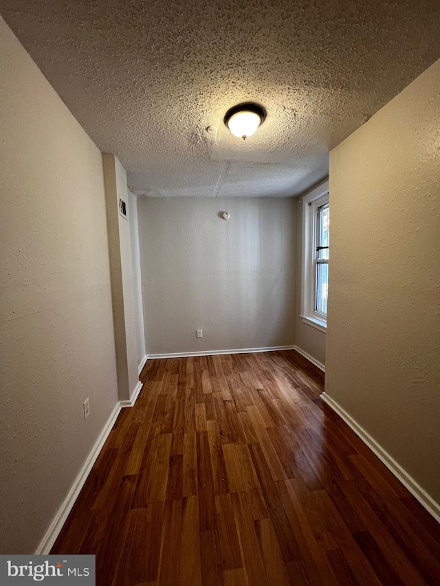 spare room with wood-type flooring and a textured ceiling