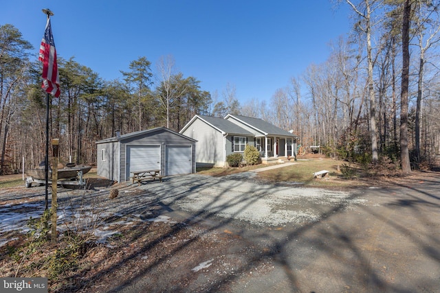 view of side of property featuring a porch, a garage, and an outdoor structure