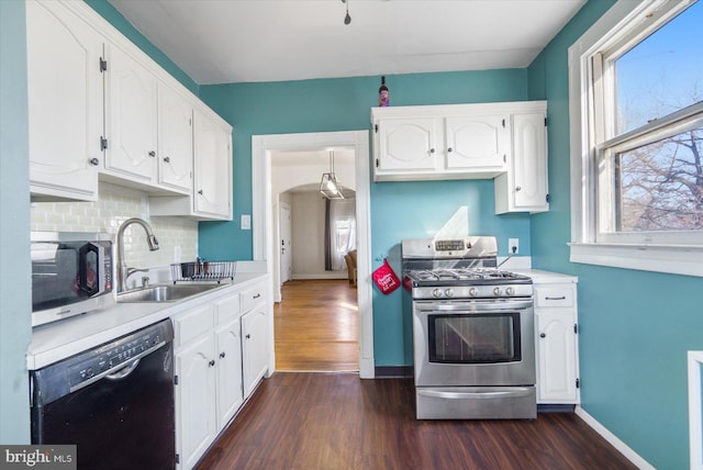 kitchen with sink, dark wood-type flooring, appliances with stainless steel finishes, white cabinetry, and tasteful backsplash