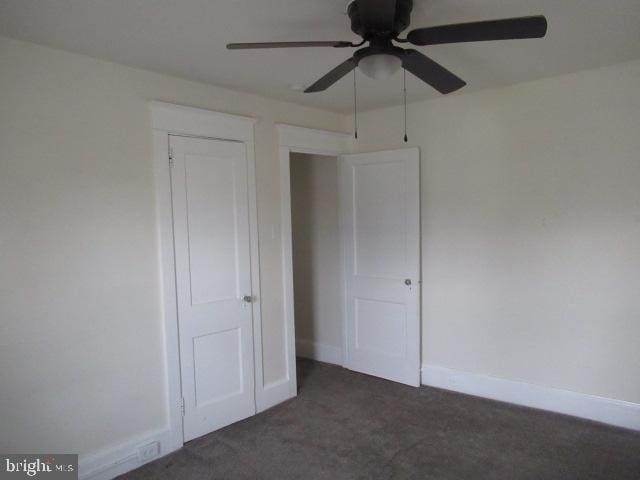 unfurnished bedroom featuring dark colored carpet and ceiling fan