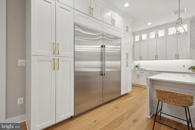 6919 Berkeley St, Falls Church, VA 22043 - kitchen featuring stainless steel built in refrigerator, light wood-style floors, white cabinetry, recessed lighting, and hanging light fixtures