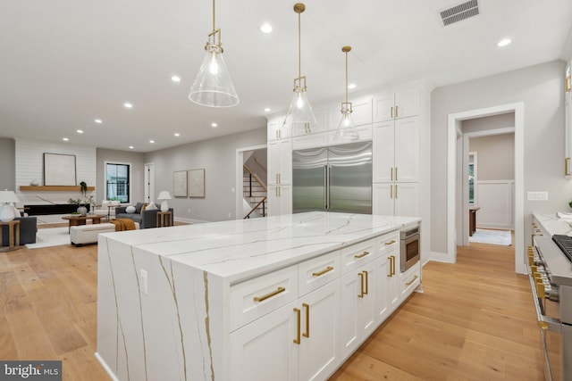 6919 Berkeley St, Falls Church, VA 22043 - kitchen with premium appliances, white cabinetry, a center island, light wood-style flooring, and recessed lighting