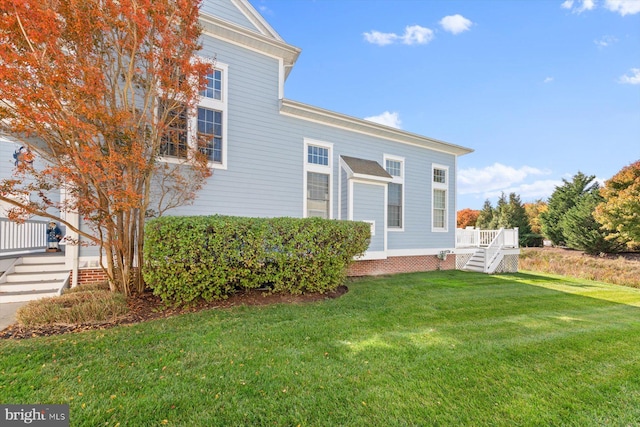 view of side of property with a wooden deck and a yard