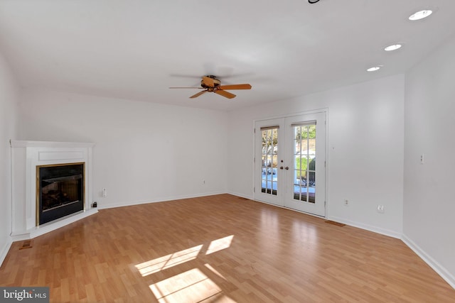 unfurnished living room featuring french doors, ceiling fan, and light hardwood / wood-style floors