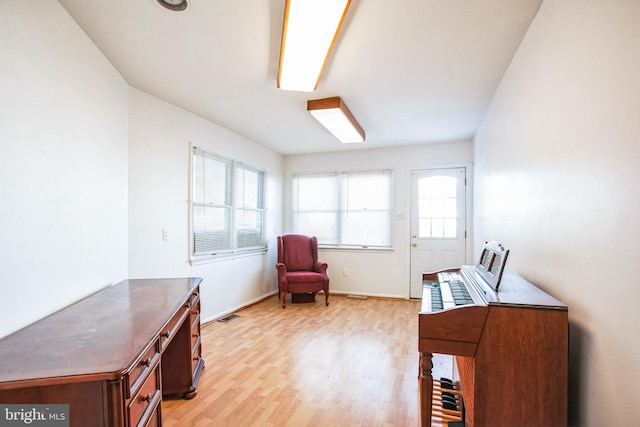 living area with a healthy amount of sunlight and light hardwood / wood-style floors