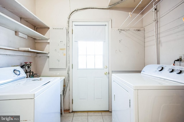 laundry room with light tile patterned flooring and washing machine and dryer