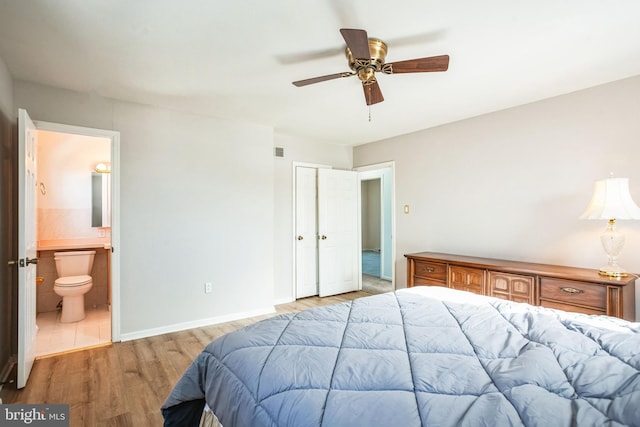 bedroom featuring ceiling fan, ensuite bathroom, and light wood-type flooring