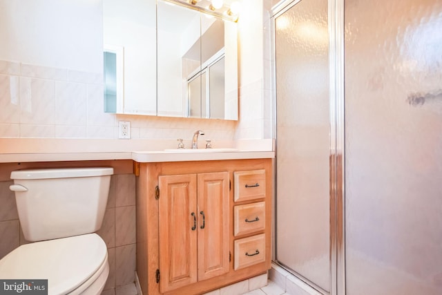 bathroom with vanity, tile walls, an enclosed shower, and toilet