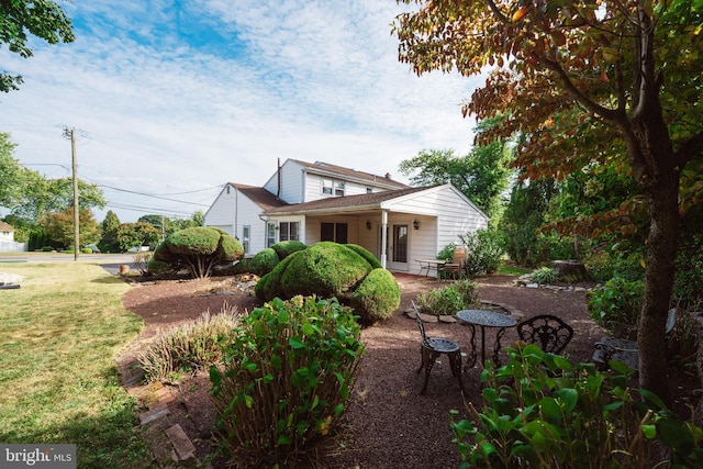 rear view of property featuring a lawn