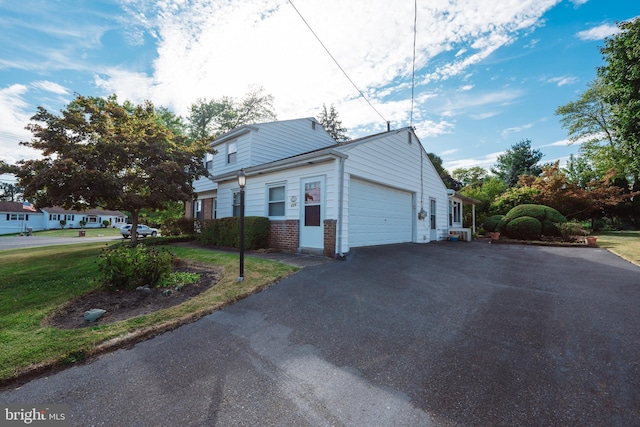 view of side of home with a garage and a lawn