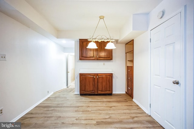 kitchen with pendant lighting, light hardwood / wood-style flooring, and a chandelier