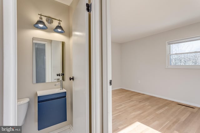 bathroom featuring vanity, hardwood / wood-style floors, and toilet