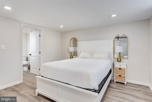 bedroom with hardwood / wood-style flooring and ensuite bathroom