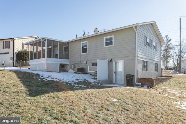 rear view of property with cooling unit, a lawn, and a sunroom