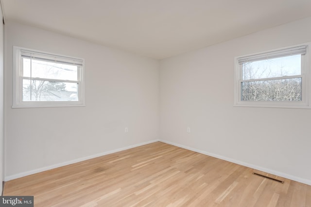 empty room with plenty of natural light and light wood-type flooring