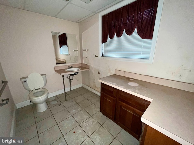 bathroom featuring a paneled ceiling, toilet, and tile patterned flooring